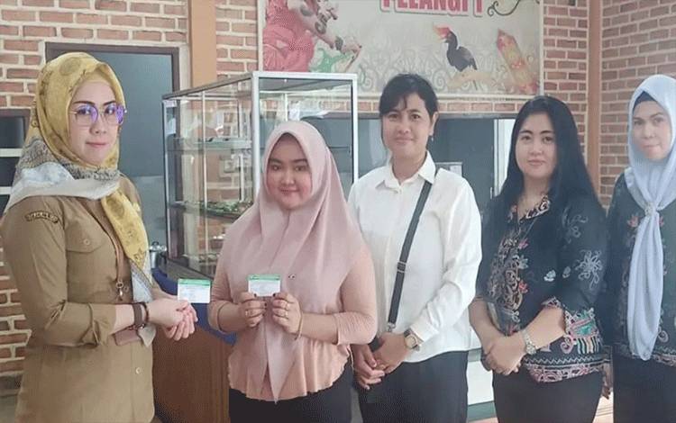 Pegawai BPPRD Palangka Raya menyerahkan NPWPD kepada pelaku usaha kuliner. (FOTO: HUMAS)