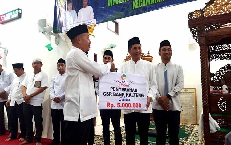Pj Bupati Barito Utara, Muhlis serahkan CSR Bank Kalteng kepada pengurus masjid Jami Darul Taqwa Kelurahan Jingah pada acara safari.(foto: Dhani)
