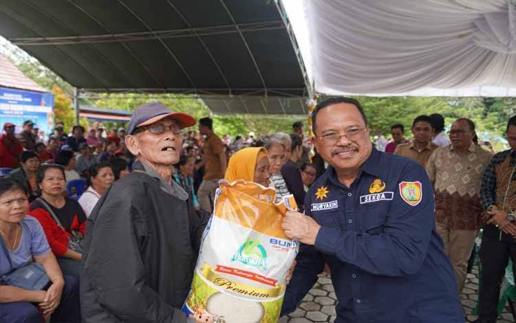Sekda Nuryakin menyerahkan beras subsidi di Desa Kandui. (FOTO:RIZALDI/TOMY)