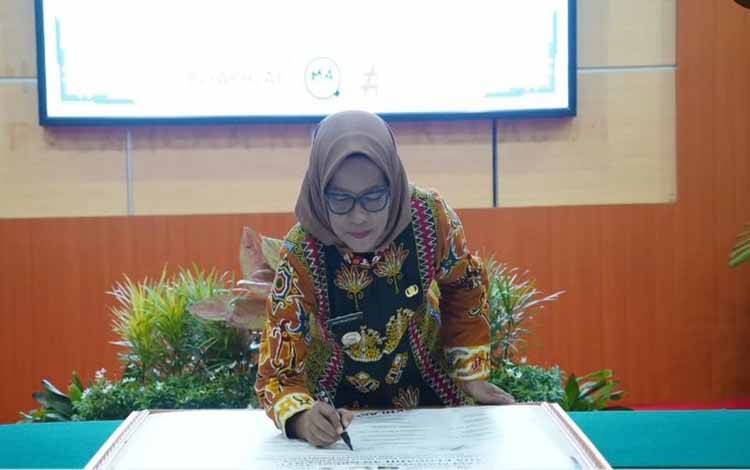 Pj Wali Kota Palangka Raya, Hera Nugrahayu menandatangani komitmen mendukung program SMAP. (FOTO: HUMAS)