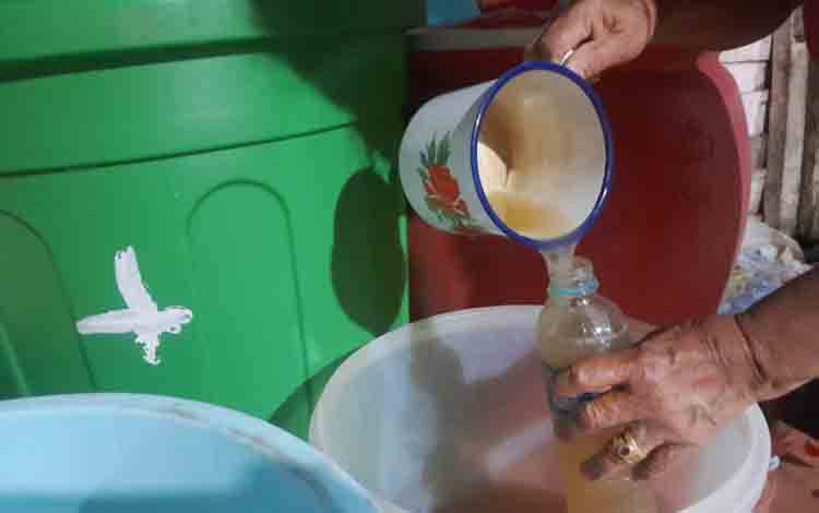 Proses memasukan Anding Madu, minuman alkohol tradisional Suku Dayak di Desa Pandawei, Kecamatan Banama Tingang, Kabupaten Pulang Pisau. (FOTO: MARINI)