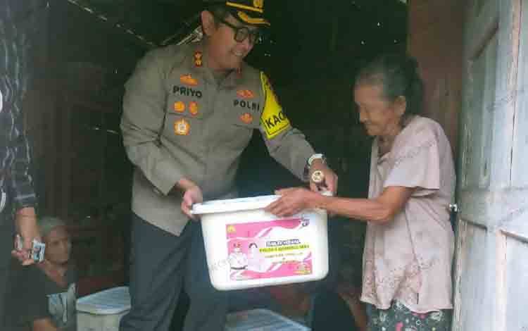 Kapolres Gunung Mas AKBP Theodorus Priyo Santosa saat menyerahkan bansos kepada masyarakat di skeitar Jalan Jambu, Kamis, 28 Maret 2024. (FOTO: HUMAS POLRES GUMAS)