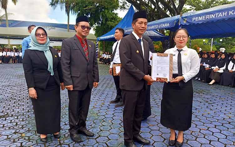 Pj Bupati Barito Utara, Muhlis didampingi Asisten Sekda bidang Administrasi Umum H Yaser Arapat dan Kepala BKPSDM, Sri Hartati menyerahkan secara simbolis SK kepada 3 orang perwakilan P3K formasi tahun 2023 di halaman kantor bupati, Selasa 2 April 2024.(foto: Dhani)