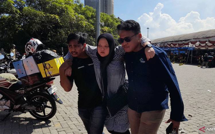 Petugas memapah pemudik yang pingsan di Pelabuhan Ciwandan, Cilegon, Banten, Minggu (7/4/2024). (ANTARA/Desi Purnama Sari)