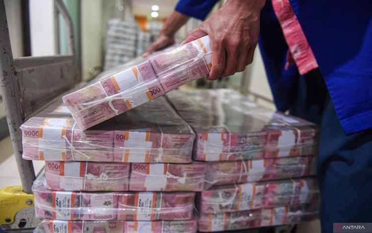 Petugas menata uang tunai di Mandiri Cash Center, Jakarta, Rabu (3/4/2024). Menurut Kamar Dagang dan Industri Indonesia (KADIN), perputaran uang selama libur lebaran yang diprediksi mencapai Rp 157,3 triliun dapat mengerek pertumbuhan ekonomi nasional pada kuartal 1-2024. ANTARA FOTO/Muhammad Adimaja/wpa.