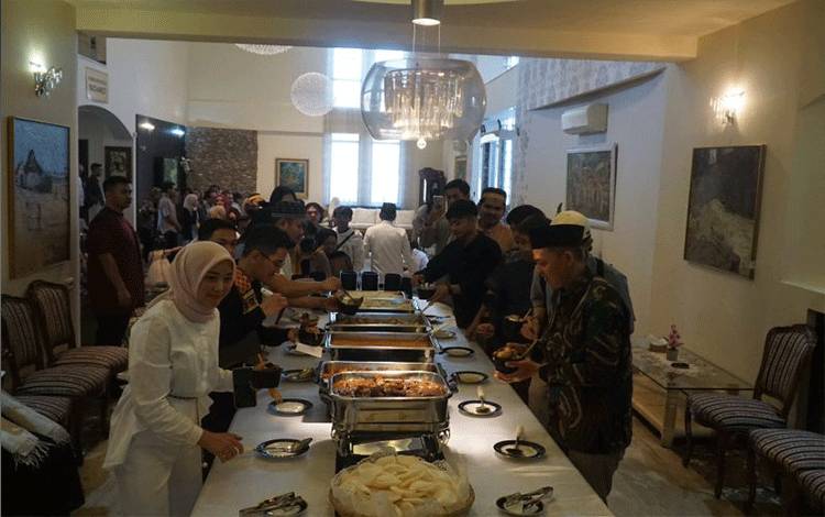 Para WNI mengantri mengambil hidangan yang disediakan dalam acara halal bihalal yang diadakan oleh KBRI Bukares dalam peringatan Idulfitri 1445 H, Rabu (10/4/2024). (ANTARA/HO-KBRI Bukares)