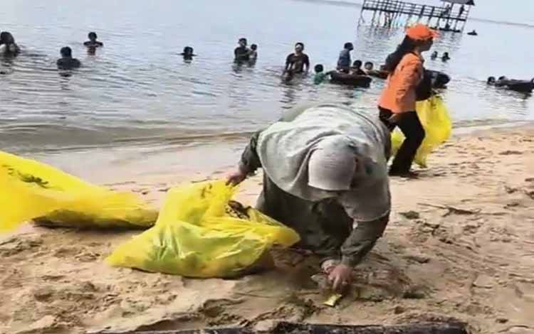 Wakil Bupati Kotawaringin Timur Irawati menyisir sampah di Pantai Ujung Pandaran, Minggu, 14 April 2024. (FOTO: IST)