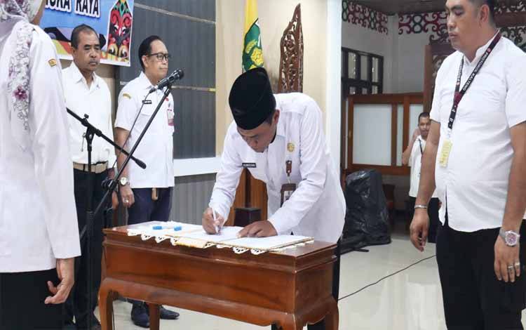 Pj Sekda Palangka Raya, Achmad Zaini meneken SK di hadapan Pj Wali Kota. (FOTO: FOTO: HENDRI)
