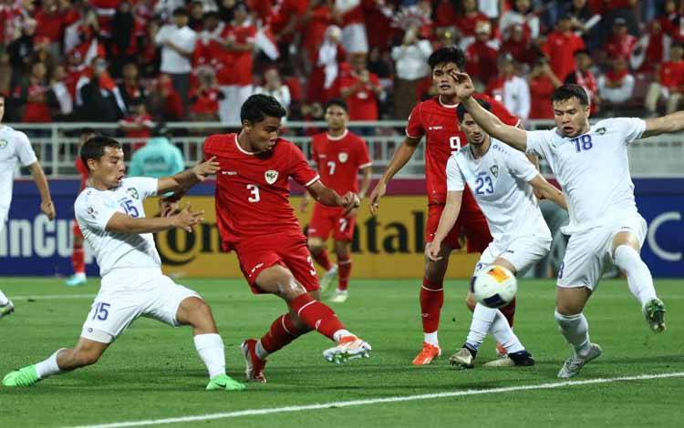 Bek timnas Indonesia' Muhammad Ferarri (kedua dari kiri) ditempel ketat gelandang Uzbekistan Umarali Rakhmonaliev (kiri) saat terjadi kemelut di muka gawang Uzbekistan ketika kedua tim bertanding di semifinal Piala Asia U23 di Abdullah Bin Khalifa Stadium, Doha, Senin (29/4/2024). (Photo by KARIM JAAFAR / AFP) (AFP/KARIM JAAFAR)