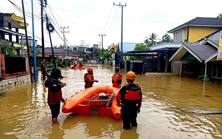 BPBD Kabupaten Barito Utara bersama Dinas Pemadam Kebakaran dan Penyelamatan Barito Utara melakukan evakuasi terhadap warga menggunakan perahu karet yang rumahnya terdampak banjir akibat hujan, Minggu 12 Mei 2024.(foto: Dhani)