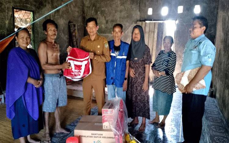 Kepala Bidang Penanganan Fakir Miskin Perlindungan dan Jaminan Sosial Dinsos PMD Barito Utara, Mujiburrahman menyerahkan bantuan untuk korban kebakaran di Desa Datai Nirui.(foto: Dhani)