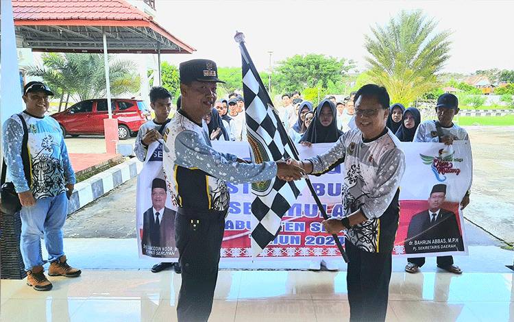 Pj Bupati Seruyan Djainuddin Noor menyerahkan bendera kepada Kadis Poraparbud Seruyan Rijali Hady selaku pimpinan kontingen (FOTO : PROKOM SERUYAN)
