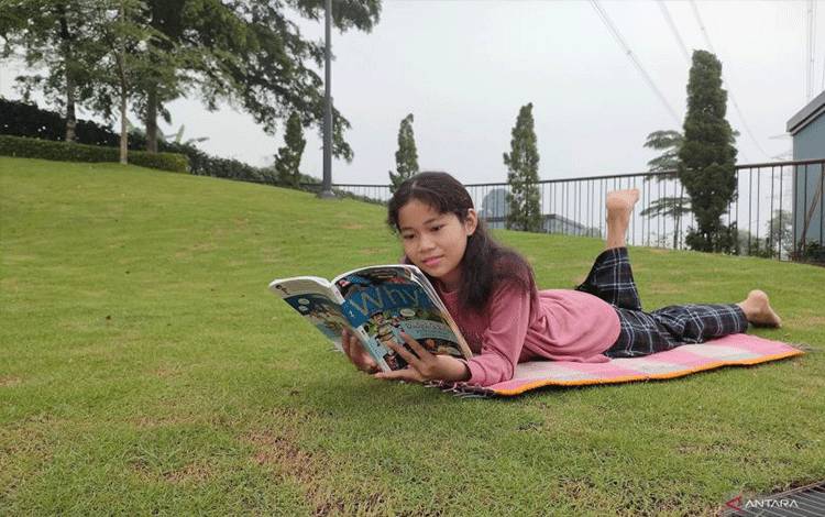 Seorang remaja membaca buku di sebuah taman. Membaca buku bisa menjadi aktivitas produktif yang menyenangkan. ANTARA/Sizuka.