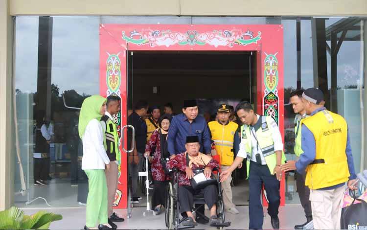 Sekda Kotim Dorong Kursi Roda CJH Menuju Pesawat Berangkat ke Embarkasi Banjarmasin