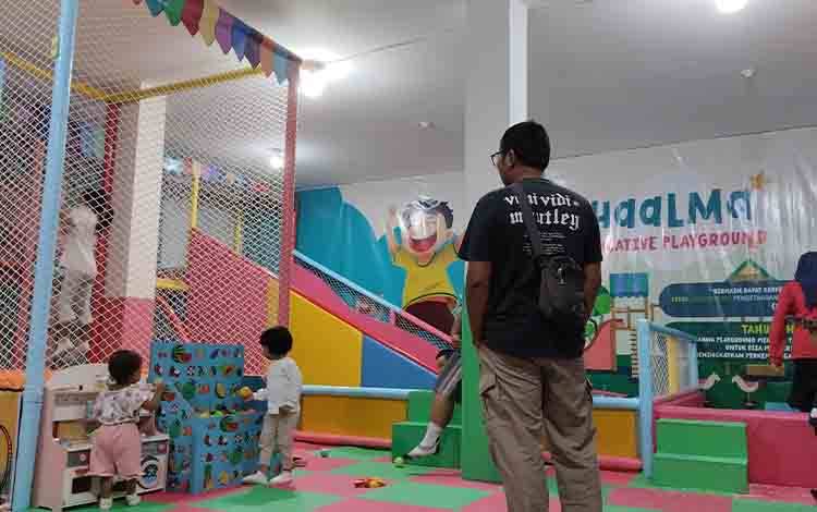 Seorang ayah menemani anak-anaknya bermain di salah satu Playground yang ada di Jalan Bukit Keminting, Palangka Raya pada Jumat, 31 Mei 2024 malam. (FOTO: TESTI PRISCILLA)