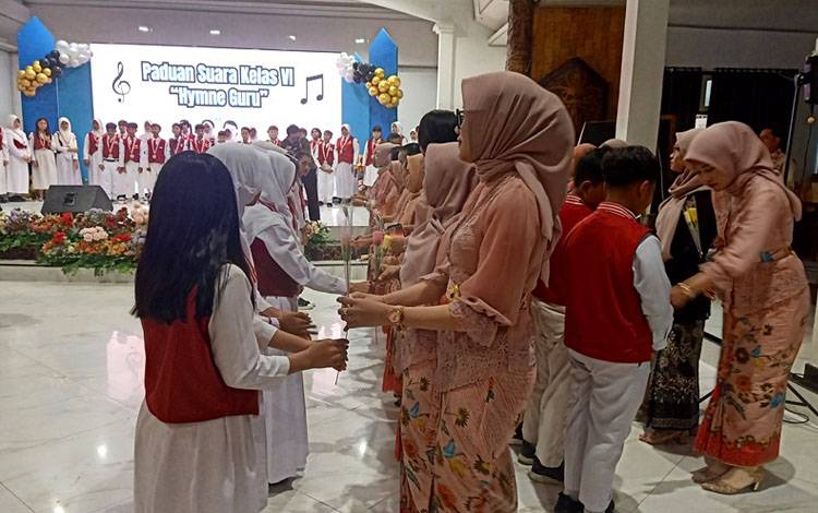 Murid SDN 5 Melayu kelas VI yang melaksanakan perpisahan dan pelepasan menyerahkan bunga kepada bapak dan ibu guru SDN 5 Melayu, bunga yang diserahkan sebagai ucapan terima kasih para siswa siswi kepada tenaga pendidik, di gedung balai Antang Muara Teweh.(foto: Dhani)