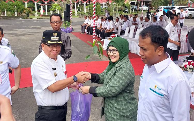 Pj Bupati Kapuas, Erlin Hardi saat menyerahkan simbolis bibit pohon sesuai upacara Peringatan Hari Lingkungan Hidup se Dunia, bertempat di halaman kantor Bupati Kapuas pada Rabu, 5 Juni 2024. (FOTO: DODI)