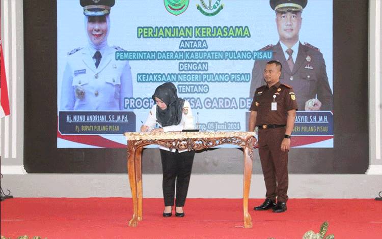 Penjabat Bupati Nunu Andriani menunjukan naskah kerjasama Program Jaksa Garda Desa atau Jaga Desa bersama Kejaksaan negeri Kabupaten Pulang Pisau yang berlangsung di Aula Banama Tingang, kantor bupati setempat, Rabu (5/6).