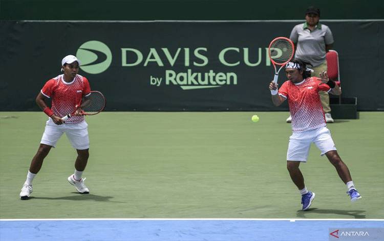 Petenis ganda putra Indonesia Christoper Rungkat (kanan) yang berpasangan dengan Muhammad Rifqi Fitriadi (kiri) mengembalikan bola ke arah lawannya petenis ganda putra Venezuela Luis David Martinez/Jordi Munoz-Abreu dalam pertandingan Playoff Grup II Piala Davis di Stadion Tenis Gelora Bung Karno, Jakarta, Sabtu (5/3/2022). ANTARA FOTO/M RISYAL HIDAYAT