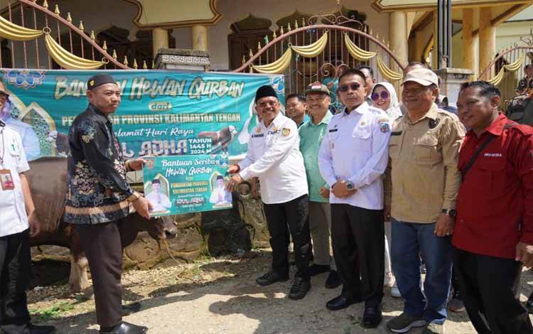 Sekda Kalteng Nuryakin menyerahkan secara simbolis hewan kurban kepada Pemkab di Kelurahan Muara Tuhup, Rabu, 12 Juni 2024. (FOTO: IKHSAN)