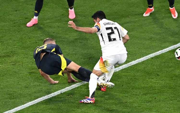 Ryan Porteous saat melakukan pelanggaran terhadap kapten jerman Ilkay Guendogan. ANTARA/AFP/THOMAS KIENZLE