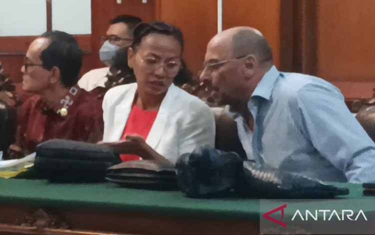 Putri Indonesia Persahabatan 2002 Fransisca Fannie Lauren Christie berdiskusi dengan suaminya Valerio Tocci saat mengikuti proses sidang PKPU di Pengadilan Niaga pada Pengadilan Negeri Surabaya, Jumat malam (21/6/2024). (ANTARA/Hanif Nashrullah)
