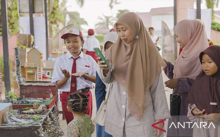 Siswa berprestasi SD Perdana Sukamara, Rifandra Muhammad Rizky Indrayanto menerang prakarya kepada pengunjung di sekolahnya. (ANTARA/Ho-Putera Sampoerna Foundation)