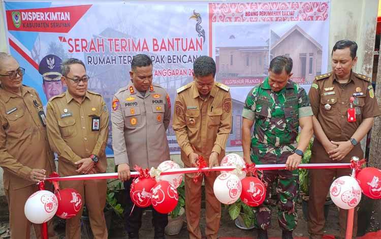 Pj Bupati Seruyan Djainuddin Noor melakukan potong pita tanda di serahkannya bantuan rumah terdampak bencana di wilayah Kuala Pembuang (Foto ; FAHRUL)
