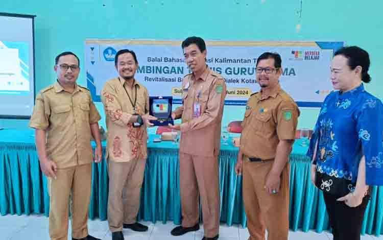 Kepala Balai Bahasa Kalteng, Muhammad Muis menyerahkan plakat dalam rangkaian kegiatan Bimtek Guru Utama program Revitalisasi Bahasa Daerah 2024 yang ditutup di Kabupaten Sukamara. (FOTO: ISTIMEWA)