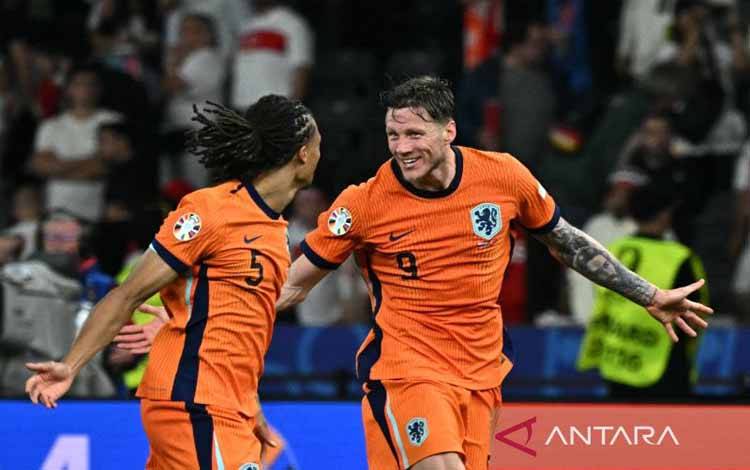 Penyerang Belanda #09 Wout Weghorst (kanan) dan bek Belanda #05 Nathan Ake merayakan setelah memenangkan pertandingan sepak bola perempat final UEFA Euro 2024 antara Belanda dan Turki di Olympiastadion di Berlin pada Sabtu (6/7/2024). (ANTARA/AFP/Javier Soriano)