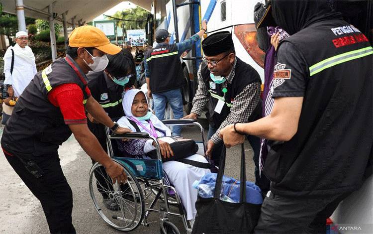 Ilustrasi - Petugas membantu seorang haji asal Provinsi Papua turun dari bus setibanya di Asrama Haji Makassar, Sulawesi Selatan, Rabu (10/7/2024). ANTARA/ARNAS PADDA