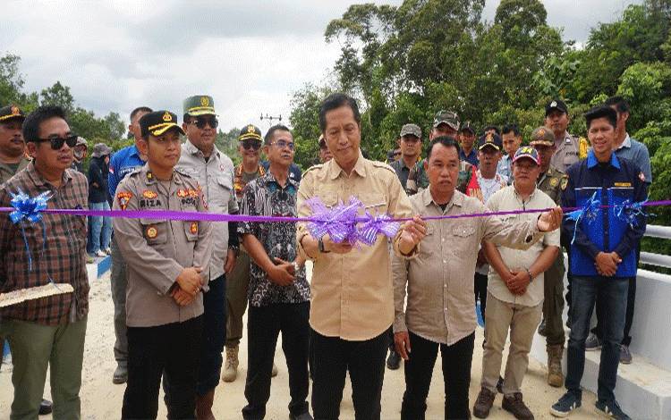 Pj Bupati Barito Utara, Drs Muhlis didampingi Wakil Ketua II DPRD Barito Utara, Sastra Jaya dan pejabat lainnya ketika menggunting pita tanda diresmikannya jembatan Sei Intu Desa Haragandang, Sabtu 13 Juli 2024. (foto: Dhani)