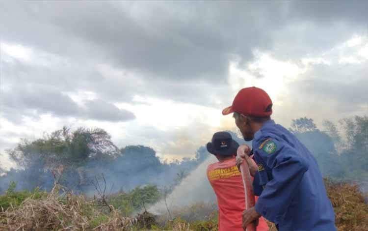 Petugas Pemadam Kebakaran saat menjinakkan api yang membakar lahan di dekat RSUD Samuda, Kecamatan Mentaya Hilir Selatan, Minggu, 14 Juli 2024. (FOTO: DISDAMKARMAT)