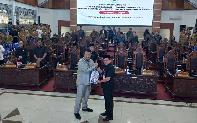 Pj Bupati Kapuas, Erlin Hardi saat menyerahkan draft Raperda tentang RPJPD Kapuas 2025 - 2045 pada Rapat Paripurna, Senin, 22 Juli 2024. (FOTO: DODI)