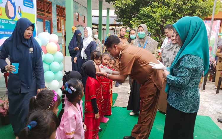 Pj Bupati Seruyan Djainuddin Noor di dampingi Pj Ketua TP PKK Seruyan, Ny. Hj. Habibah Djainuddin Noor meneteskan imunisasi polio kepada salah satu anak pada pencanangan Pin Polio (Foto : Fahrul)