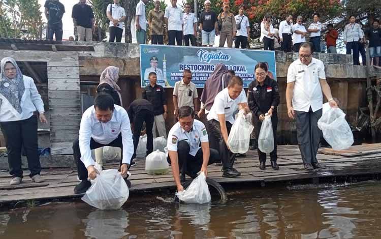 Pejabat Bupati Sukamara Kaspinor bersama kepala SOPD saat melepas benih ikan ke Sungai Jelai, Rabu, 24 Juli 2024. (FOTO:NORHASANAH)