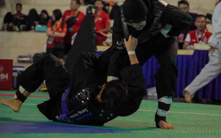 Pesilat Indonesia Delly Salsafitri (kanan) berusaha membanting pesilat Thailand Putthachat (kirir) pada nomor tanding putri Class D, ASEAN University Games 2024 di Universitas Muhammadiyah Malang (UMM) Dome, Malang, Jawa Timur, Jumat (5/7/2024). Kontingen pencak silat Indonesia meraih enam medali emas dalam ajang ASEAN University Games 2024. ANTARA FOTO/Irfan Sumanjaya/nz