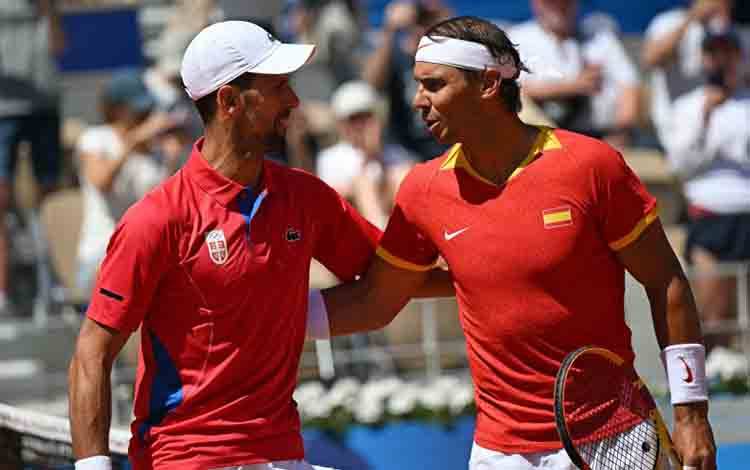 Petenis Serbia Novak Djokovic (kiri) bersama petenis Spanyol Rafael Nadal (kanan) berbicara sebelum pertandingan nomor tunggal babak kedua Olimpiade Paris 2024 di Lapangan Philippe-Chatrier, Roland Garros, Paris, Senin (29/7/2024). (ANTARA/AFP/Martin Bernetti)