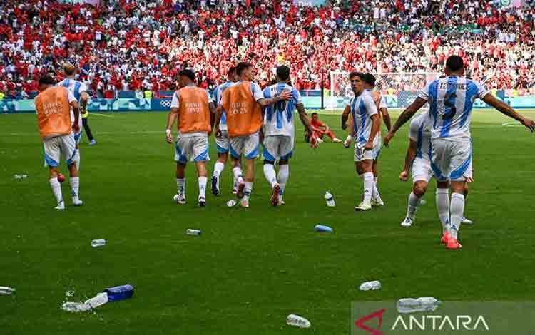 Arsip - Pemain depan Timnas Argentina Giuliano Simeone (dua kanan) melihat botol-botol bekas minuman yang dilemparkan para pendukung Maroko ke lapangan saat pertandingan penyisihan grup B sepakbola putra Olimpiade Paris 2024 di Geoffroy-Guichard Stadium, Saint-Etienne, Prancis, Rabu (24/7/2024). ANTARA/AFP/Arnaud Finistre/aa.