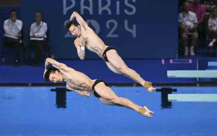 Long Daoyi dan Wang Zongyuan memenangkan medali emas untuk China dari loncat indah setelah menjuarai papan 3m putra Olimpiade Paris 2024 di Aquatics Centre di Saint-Denis, Paris, pada 2 Agustus 2024. (AFP/SEBASTIEN BOZON)