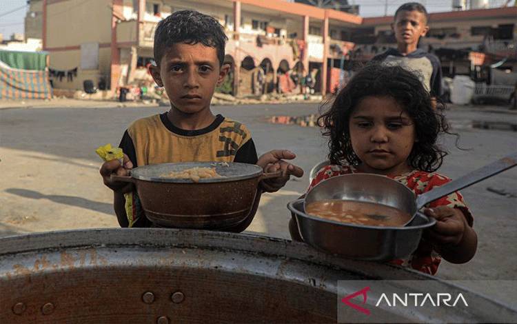 Arsip - Anak-anak Palestina antre makanan di Kota Khan Younis, Jalur Gaza Selatan, pada 15 Juni 2024. (ANTARA FOTO/Xinhua/Rizek Abdeljawad/Spt)