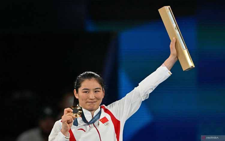 Peraih medali emas Li Qian dari Tiongkok merayakan di podium saat upacara perebutan medali kategori tinju final 75kg putri pada Olimpiade Paris 2024 di Stadion Roland-Garros, di Paris pada Sabtu (10/8/2024). (ANTARA/AFP/Mohd Rasfan)