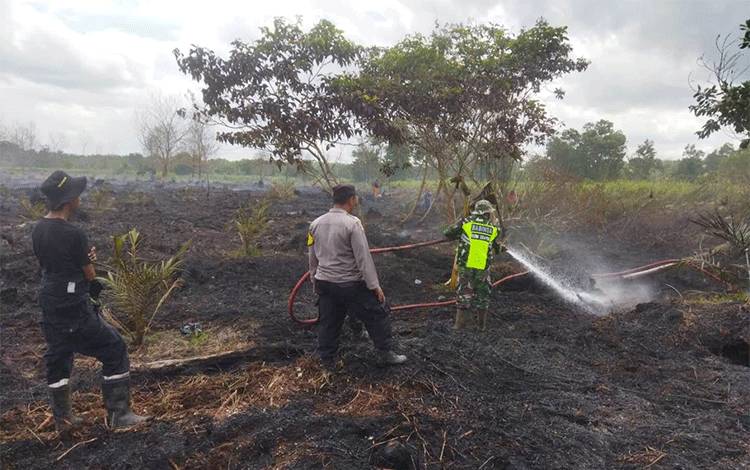 Babinsa dan Bhabinkamtibmas Sei Tendang saat melakukan pendinginan dalam penanganan Kebakaran lahan. (Foto : Kodim 1014/Pbn)