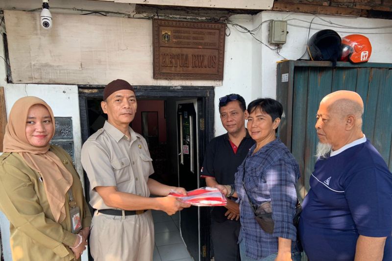 Suku Dinas Komunikasi, Informatika dan Statistik (Kominfotik) Jakarta Pusat membagikan bendera merah putih di permukiman warga RW 08 Kelurahan Petojo Selatan, Gambir, Jakarta Pusat, Selasa (13/8/2024). ANTARA/Ho/Pemerintah Kota Jakarta Pusat