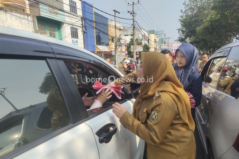 Wali Kota Bandarlampung Eva Dwiana saat membagikan bendera merah putih kepada masyarakat di Jalan Teuku Umar. Bandarlampung, Selasa (13/8/2024). (ANTARA/Dian Hadiyatna)
