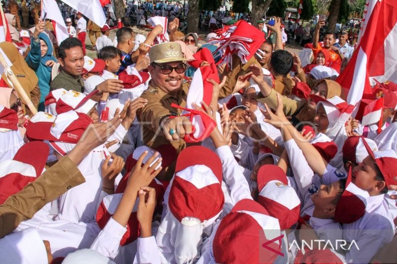Arsip Foto - Penjabat Wali Kota Lhokseumawe A Hanan (tengah) membagikan Bendera Merah Putih kepada pelajar dalam apel Gerakan Pembagian 10 juta Bendera Merah Putih 2024 di Lhokseumawe, Aceh, Senin (10/6/2024). (ANTARA FOTO/Rahmad)