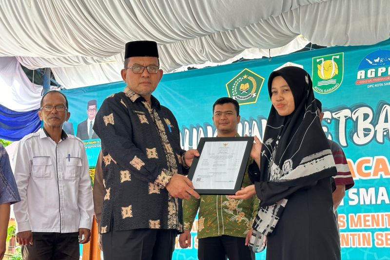 Kepala Kanwil Kementerian Agama (Kemenag) Aceh Azhari saat menyerahkan sertifikat halal kepada pemilik usaha secara simbolis di Kota Sabang, Aceh, Rabu (14/8/2024). (ANTARA/HO-Kemenag Aceh)