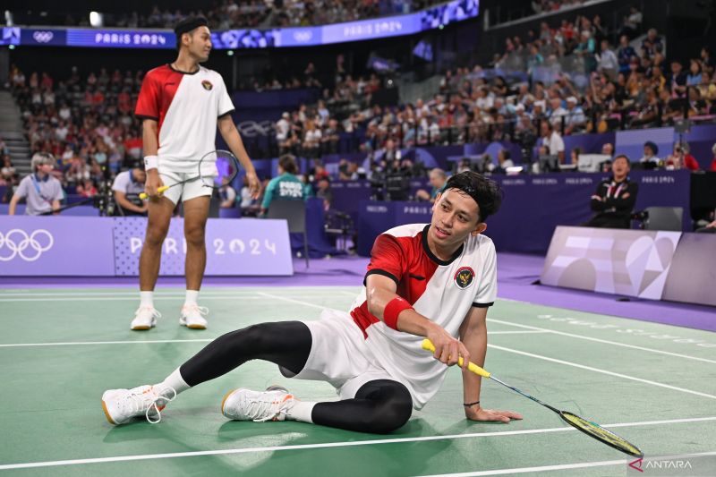 Pebulu tangkis ganda putra Indonesia Muhammad Rian Ardianto (kanan) terjatuh dengan disaksikan rekannya Fajar Alfian saat bertanding melawan ganda putra China Liang Wei Keng/Wang Chang pada babak perempat final Olimpiade Paris 2024 di Porte De La Chapella Arena, Paris, Prancis, Kamis (1/8/2024). Ganda putra Indonesia kalah dengan skor 22-24, 20-22 atas ganda putra China. ANTARA FOTO/Wahyu Putro A/YU (WAHYU PUTRO A/Wahyu Putro A)