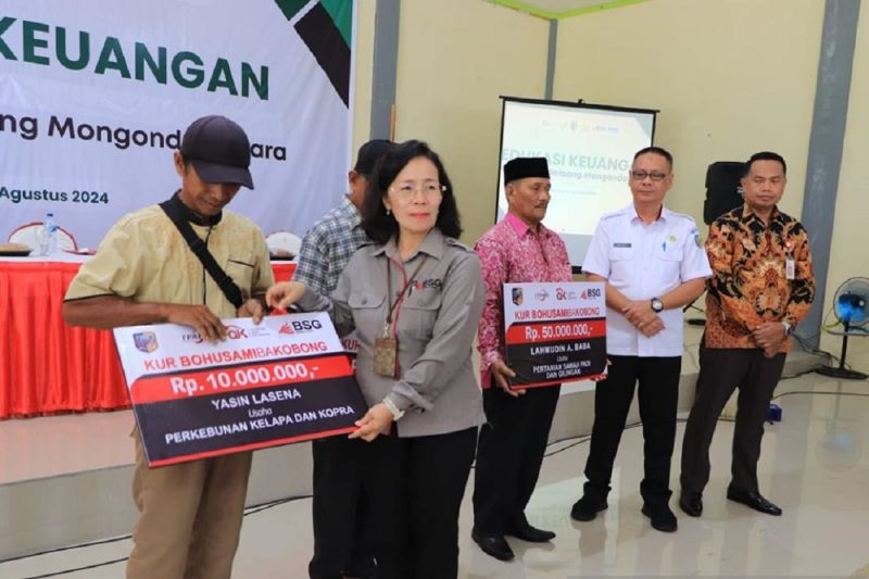 Direktur Operasional BSG Louisa Parengkuan dan Kepala OJK Sulutgomalut Robert Sianipar, saat menyerahkan KUR kepada UMKM dan petani, di Bolmong, Kamis (15/8/2024). ANTARA/HO-BSG.