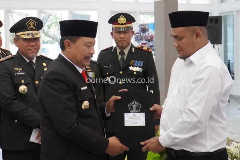 Penjabat Bupati Garut Barnas Adjidin (kiri) didampingi Kepala Lapas Garut Kelas IIB Rusdedy menyerahkan surat keputusan mendapatkan remisi Kemerdekaan Indonesia kepada narapidana di Pendopo, Kabupaten Garut, Jawa Barat, Sabtu (17/8/2024). (ANTARA/HO-Lapas Garut)